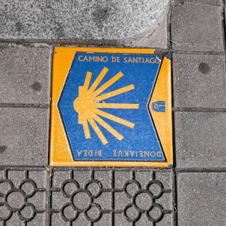 The blue and yellow camino marker. It says 'Camino de Santiago' on it.