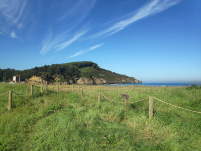 Some unimposing cliffs in the distance, lush green vegetation.
