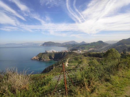 A view back along the coast, lots of greenery and ocean and hills.