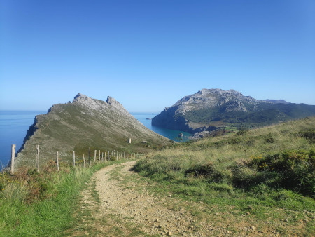 Taken from top of a hill. A dusty path that leads back along two cliffs.